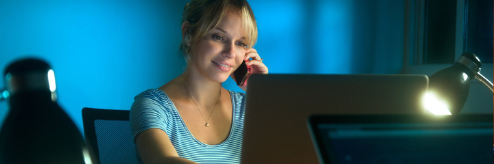 Woman on the phone looking at a computer monitor.