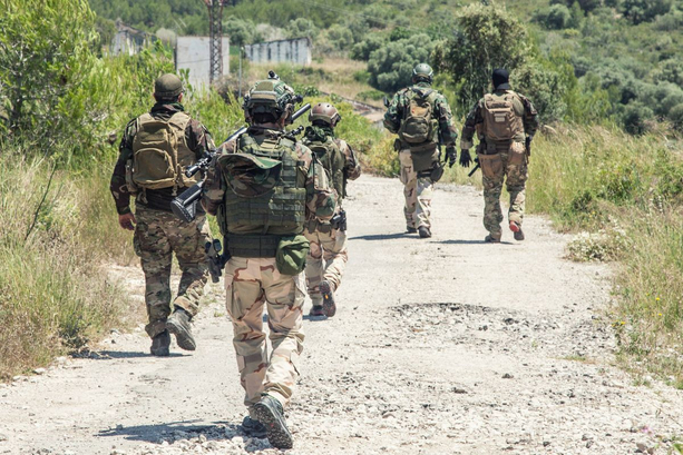 A group of soldiers on patrol walking down a gravel track