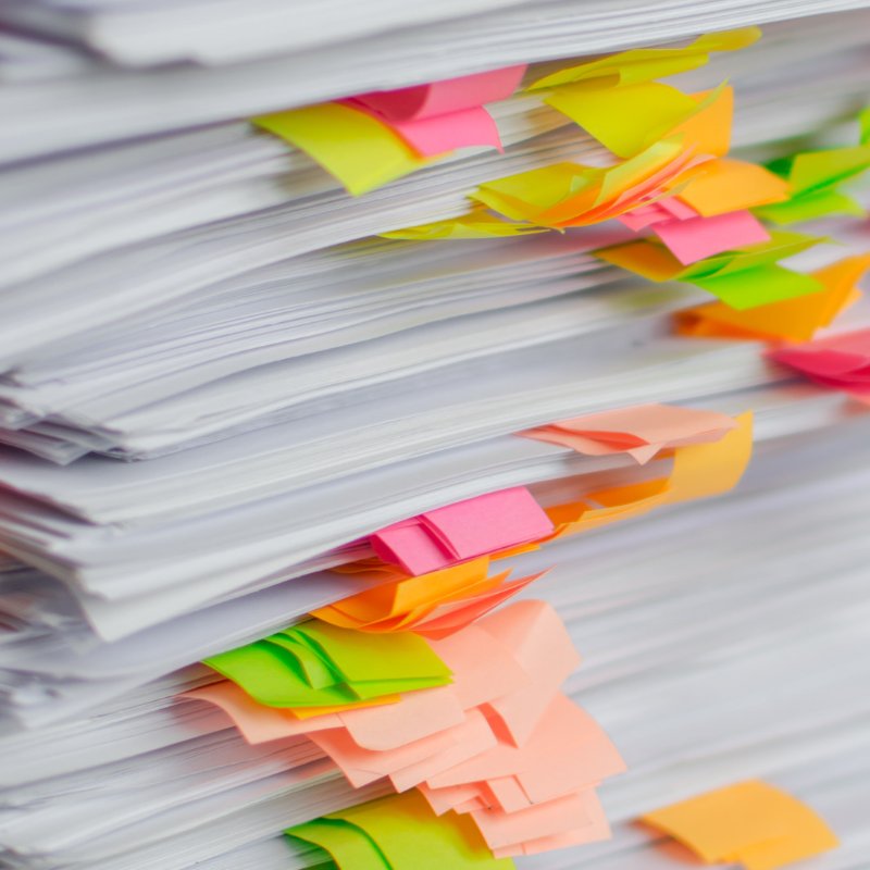 A stack of documents with coloured tags.