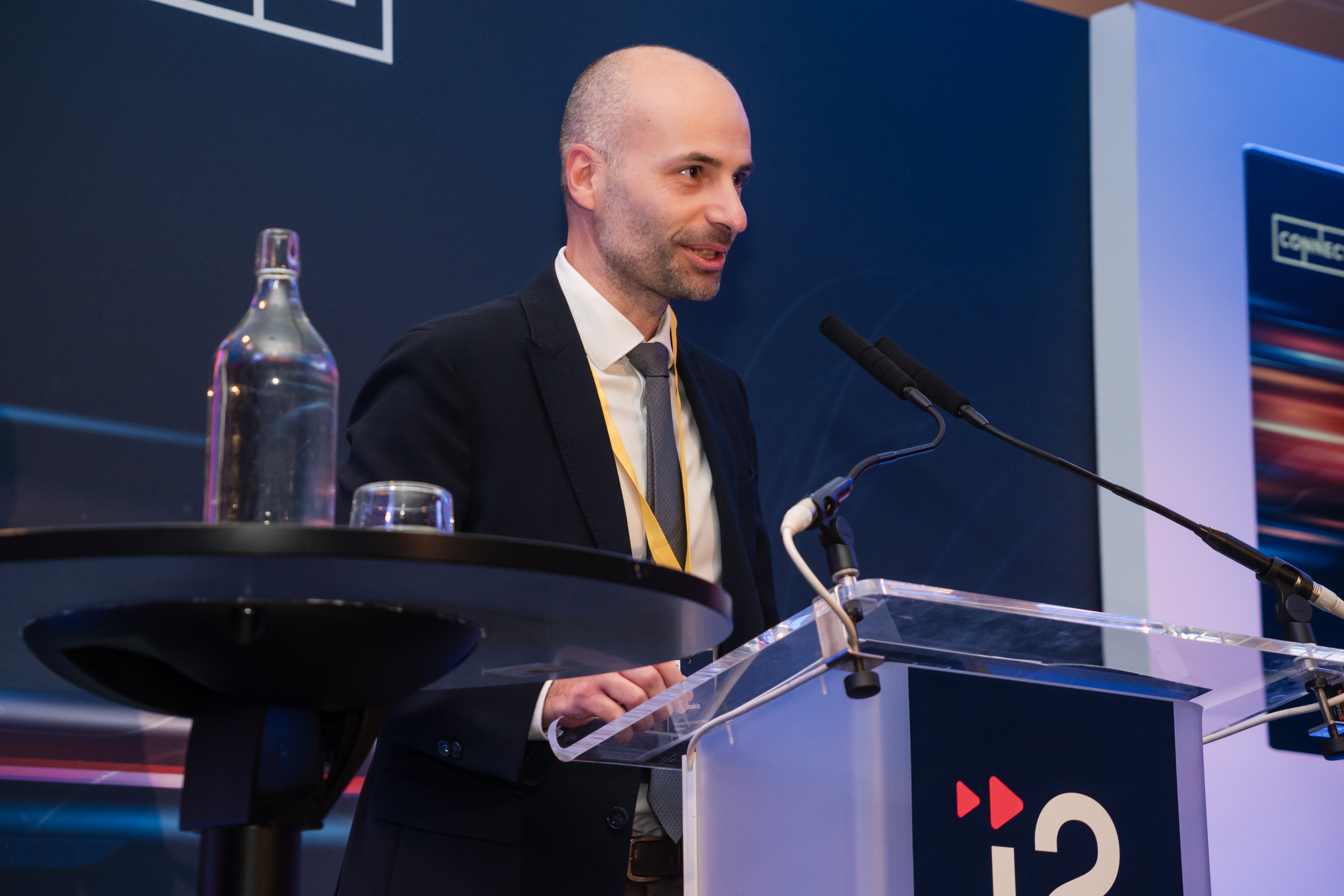 An i2 speaker presenting at the lectern